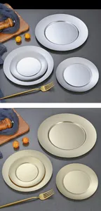 Gros plan d'assiettes rondes en acier inoxydable mat doré et argenté dans un décor élégant