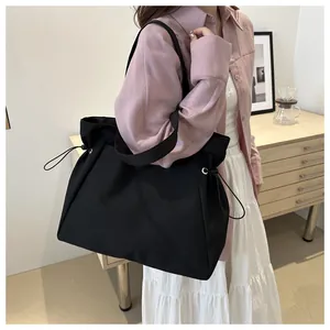 Large capacity black canvas tote bag shown on model for daily commuting and school use