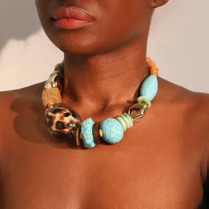 Close-up of bohemian turquoise and leopard print necklace on dark skin