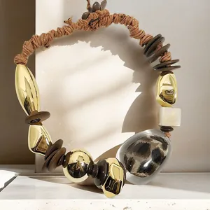 Close-up detail of bohemian woven necklace with leopard print stone and gold elements