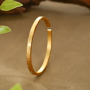 Close-up of an ancient style sand gold bangle with traditional Chinese etchings