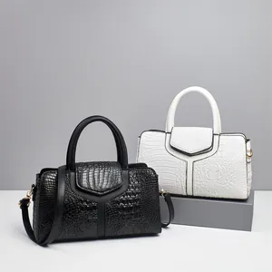 Elegant black and white crocodile pattern top-handle handbags on a studio background