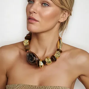 Detail view of bohemian necklace with leopard print wood beads and gold metal accents.