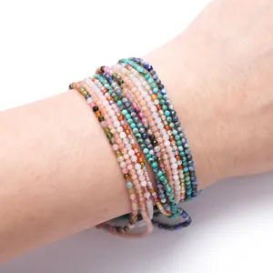 Close-up of 2-2.5mm faceted natural stone beads wrapped around a human wrist