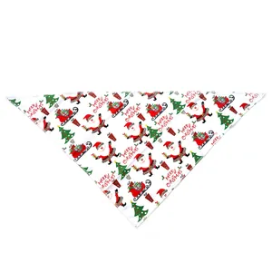 Détail d'un bandana de Noël pour animaux avec imprimés de Père Noël et de sapins sur fond blanc.