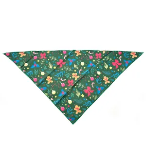 Vue à plat d'un bandana de Noël vert pour animaux avec motifs de bonhomme de pain d'épices et cannes