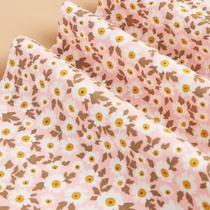 Primer plano detallado de tela de algodón rosa con un estampado romántico de margaritas