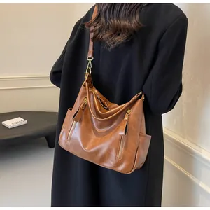Detailed view of a stylish brown retro large-capacity tote bag worn with a black coat