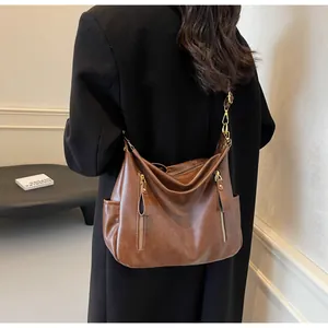 Model wearing a vintage brown large capacity faux leather hobo shoulder bag with zipper details