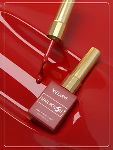 Macro detail of glossy cherry red nail polish gel with brush and gold cap