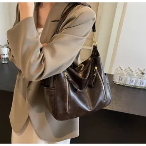 Close-up detail of large vintage brown leather tote bag with stylish vertical zippers