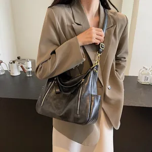 Stylish vintage black leather large capacity tote bag worn by a model in a brown blazer