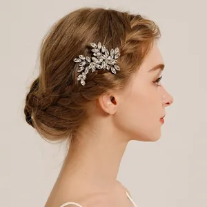 Detail shot of crystal leaf hair clip elegantly styled in a braided bridal updo