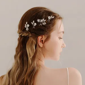 Detail of bridal pearl and rhinestone U-shaped hairpins in an elegant braided hairstyle
