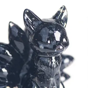 Close-up detail of a glossy black resin mythical nine-tailed fox figurine.