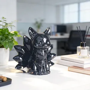 Detailed close-up of a cute black resin nine-tailed fox figurine on a sunlit desk