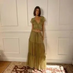 Elegant olive green tiered maxi dress worn by a model in a classic interior setting