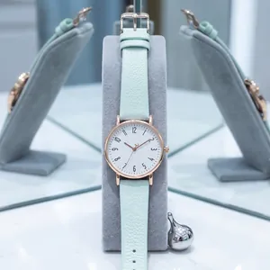 Detail of minimalist women's quartz watch with mint green lychee pattern leather strap