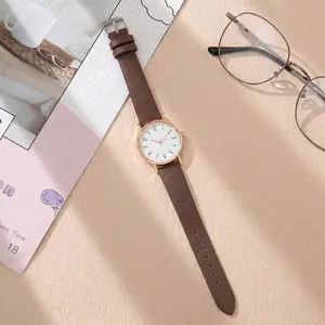 Top view of minimalist women's quartz watch with brown lychee leather strap and gold case