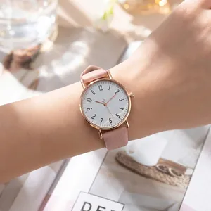 Elegant minimalist women's quartz watch featuring a pink lychee leather strap on wrist
