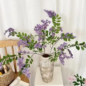 Elegantes künstliches Arrangement aus lila Akazienblüten in einer Vintage-Keramikvase