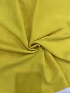 Detailed close-up view showing the smooth yellow fabric texture for a summer jumpsuit.