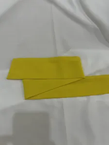 Detailed close-up showing the vibrant yellow fabric belt of a summer jumpsuit accessory.