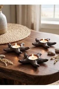 Decorative vintage cast iron starfish tea light candle holders on a rustic wooden table