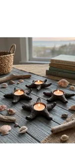 Detailed view of cast iron starfish candle holders with lit tea lights on rustic table.