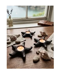 Detailed view of three vintage starfish cast iron candle holders arranged on a rustic wooden table