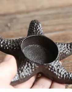 Close-up detail of vintage cast iron starfish candle holder showing rough rustic texture