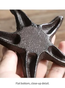 Close-up of vintage cast iron starfish candle holder with textured surface and flat bottom.