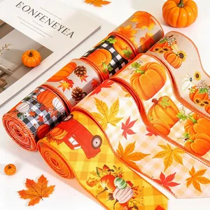Close-up detail of autumn themed linen ribbons with festive pumpkin and maple leaf prints.