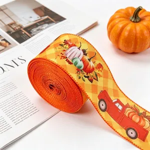 Detailed view of autumn harvest ribbon with orange pumpkin and red truck prints