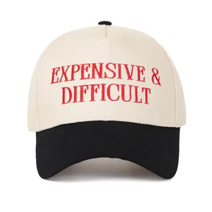 Λεπτομέρεια κεντήματος 'EXPENSIVE & DIFFICULT' σε μπεζ και μαύρο καπέλο trucker