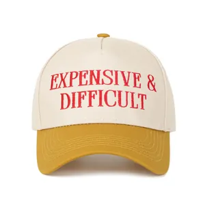 Κοντινό πλάνο του κόκκινου κεντήματος 'Expensive & Difficult' στο δίχρωμο καπέλο.