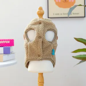 Detail view of beige teddy fleece pet vest showing warm texture and snap buttons