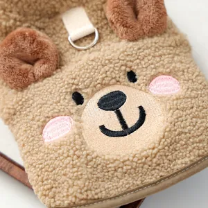 Close-up detail of cute plush bear embroidery on a soft brown warm pet winter jacket vest