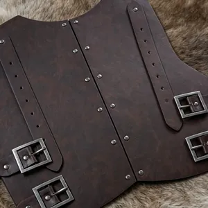 Detalle del peto de cuero marrón de estilo renacentista con hebillas y remaches metálicos.