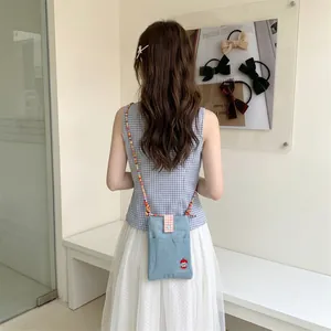 Back view of a cute denim crossbody bag with apple embroidery and beaded strap