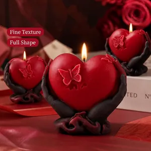 Romantic heart-shaped scented candle with hands holding design and butterfly relief.
