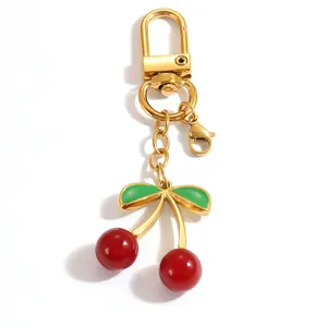Detailed view of red cherry keychain with green leaves and gold stainless steel clasps
