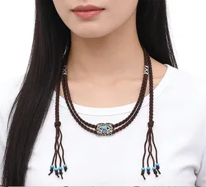 Close-up of a handmade braided ethnic hair rope with tassels and beads on a female model.