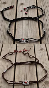 Detailed view of handmade woven ethnic hair ropes with vintage silver beads and red tassels