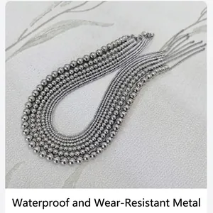 Macro view of multiple strands of polished stainless steel round beaded necklaces