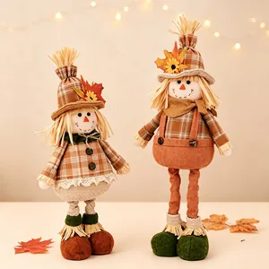 Festive pair of decorative Thanksgiving scarecrow dolls featuring autumn maple leaf straw hats