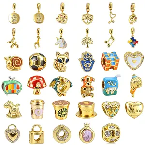 Collection of assorted gold-plated charms with colorful enamel and rhinestone details.