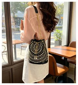 Borsa a secchiello nera stile punk con borchie e strass indossata da una modella