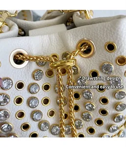 Primo piano della borsa a secchiello bianca stile punk con catena dorata e strass