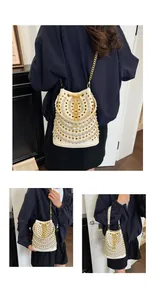 Modella che indossa una borsa a secchiello bianca stile punk con strass e occhielli.
